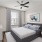 bedroom with a large window and ceiling fan above a bed
