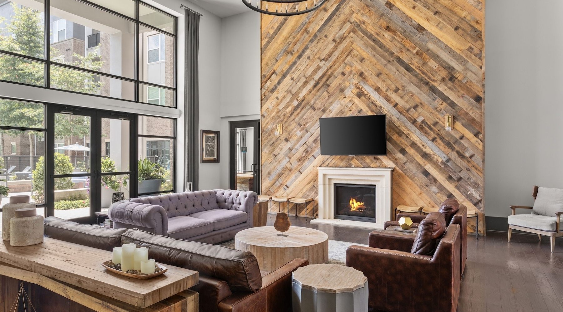 clubhouse with large windows and seating area with a fireplace and tv