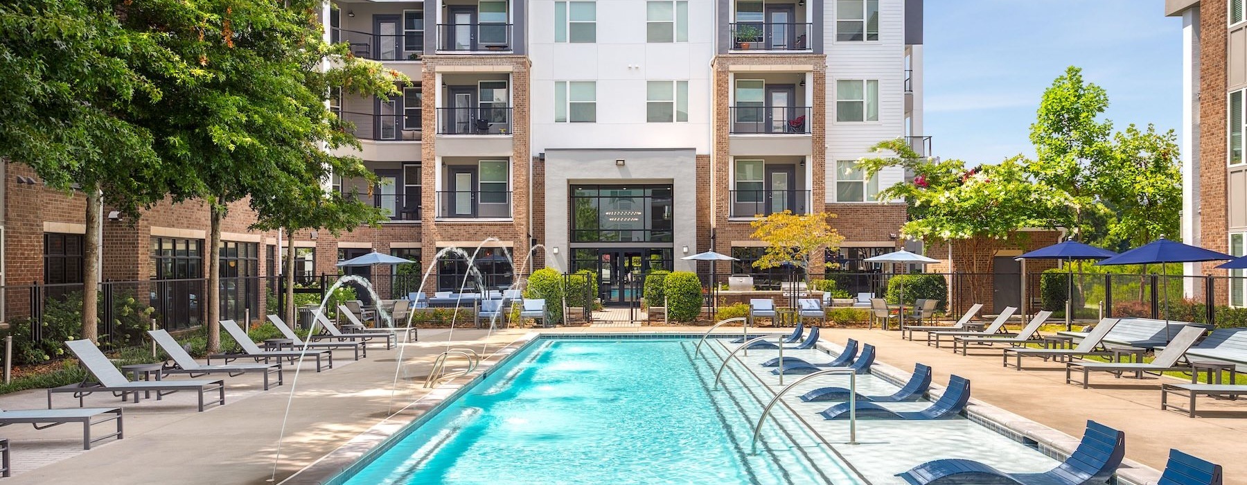 swimming pool in a courtyard with lounge chairs