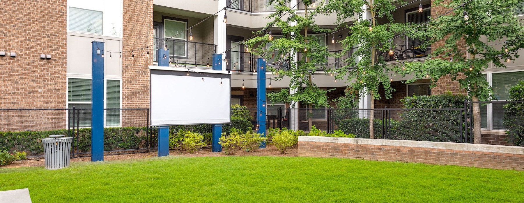 outdoor projection screen in a courtyard next to a brick building